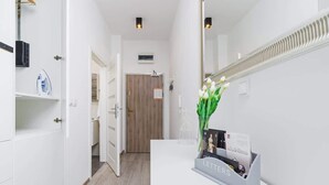 A hotel reception area with a white counter, a mirror, a vase with flowers, and a 'Letters' display. - Bright Studio in the Center | Close to Kleparski Park (Kraków)