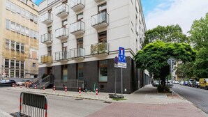 A multi-story building with balconies, a parking sign, and a pedestrian pathway. - Bright Studio in the Center | Close to Kleparski Park (Kraków)