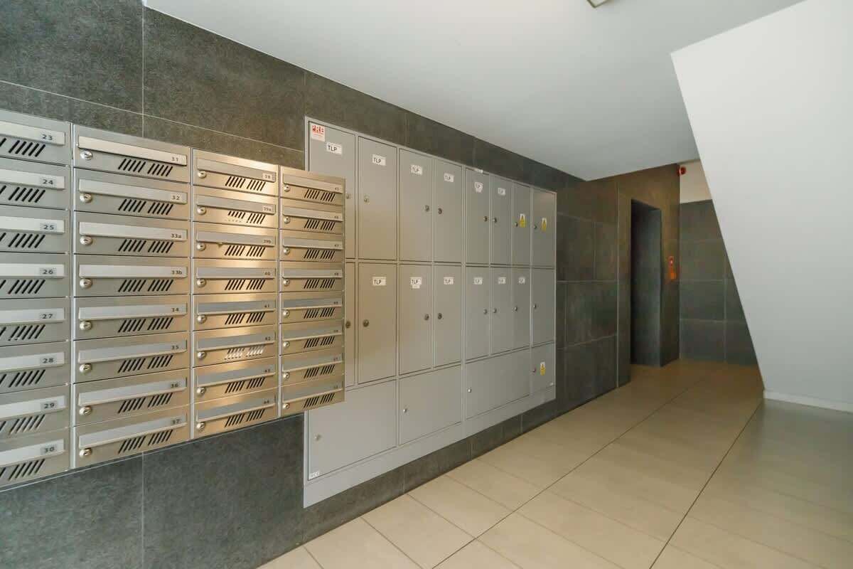 A row of lockers with numbers on the doors, a tiled floor, and a modern interior design.