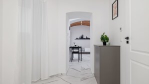 Ein Korridor mit weißem Marmorboden, einem grauen Schrank und einem schwarzen Stuhl.