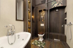 Un baño moderno con bañera, inodoro y zona de ducha.