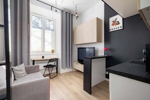 A modern living room with a sofa, a dining table, and a TV.