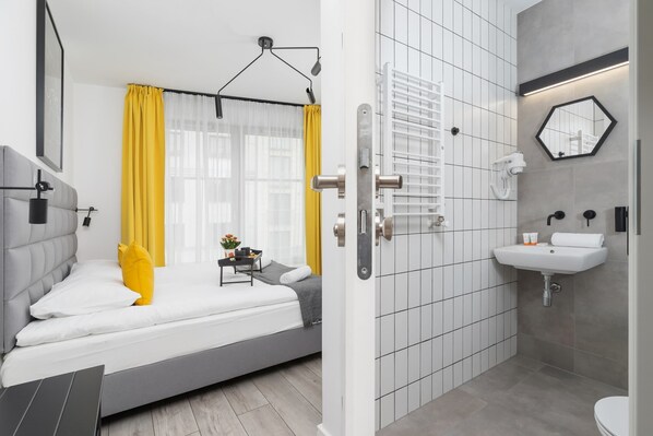 A modern bedroom with a bed, bedside table, and a view of the bathroom.