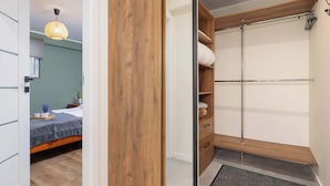 Un dormitorio con cama, mesita de noche y lámpara colgante.