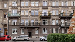 Un edificio de varias plantas con un estilo arquitectónico clásico, que cuenta con una entrada central, balcones y una fachada uniforme.