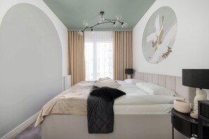Une chambre à coucher avec un lit, une table de chevet, une lampe, un tableau au mur et une fenêtre avec des rideaux.