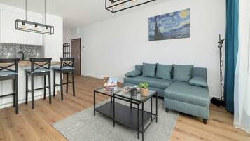 Un salon moderne avec un canapé, une table basse et un tableau accroché au mur.