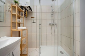 Chuveiro, secador de cabelo, toalhas de banho, shampoo