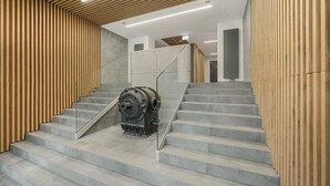 A staircase with a modern design, featuring wooden paneling on the walls and a glass railing.