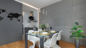 A modern dining area with a glass table, white chairs, and a world map on the wall.