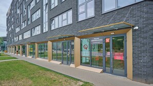 Un bâtiment moderne doté de grandes fenêtres et d’une entrée en verre.
