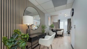 Un intérieur moderne avec un bureau, une chaise, une plante en pot et un grand miroir.