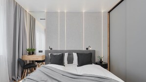 Un dormitorio moderno con cama, mesitas de noche, un escritorio y una silla.