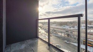 Una habitación con un amplio ventanal que da a un complejo entramado de autopistas con nieve en el suelo.