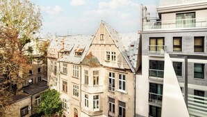 A multi-story building with a mix of architectural styles, including a traditional building with a steep roof and a modern structure with large windows.
