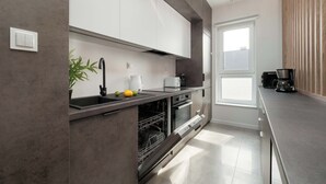 Una cocina moderna con lavavajillas, horno y cafetera.