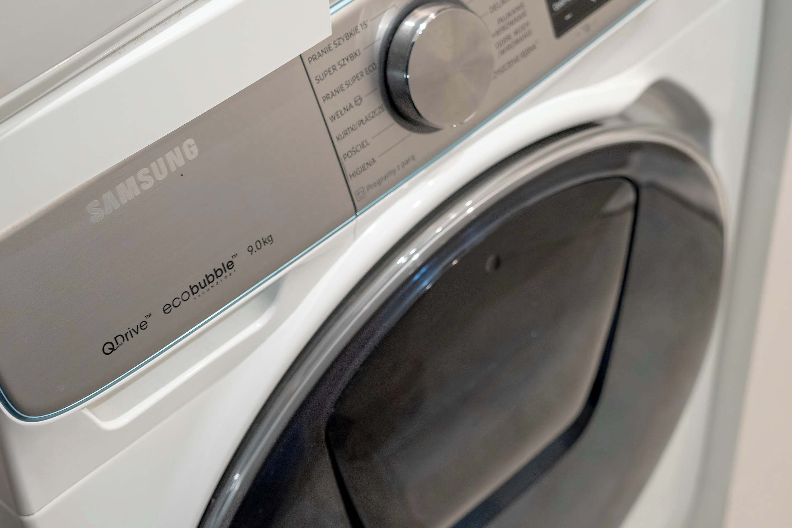 A Samsung washing machine with a control panel and a glass door.