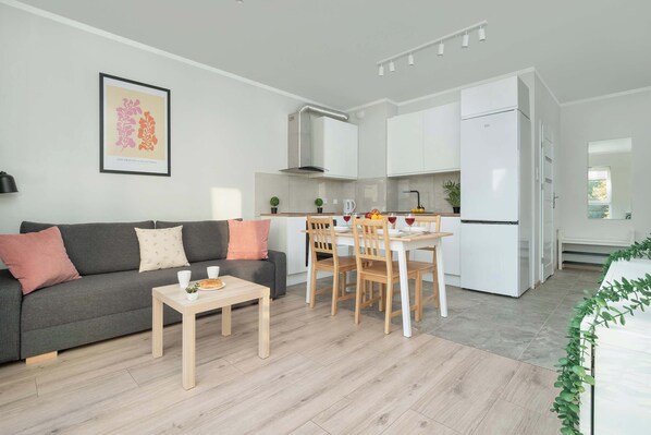 A modern apartment with a dining area, kitchen, and living room.