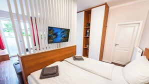 A bedroom with two beds, a TV mounted on a wall, and a wardrobe. - Zum Brandenburger Tor 01 (Damme)