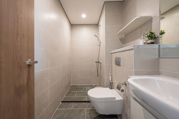 A modern bathroom with a shower, toilet, and bathtub.
