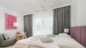 Une chambre d’hôtel moderne dotée d’un grand lit, d’un coin salon et offrant une vue sur la ville.