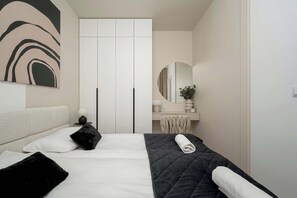 A bedroom with a bed, a bedside table, a mirror, and a wardrobe.