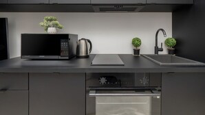 Eine moderne Küche mit integriertem Mikrowellenherd, Wasserkocher und Spüle.