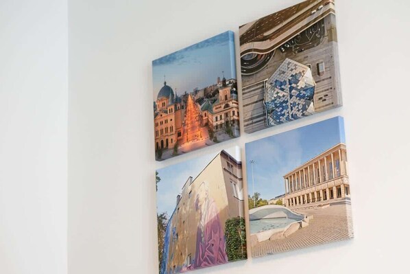 Una pared con cuatro obras de arte enmarcadas que muestran escenas arquitectónicas.