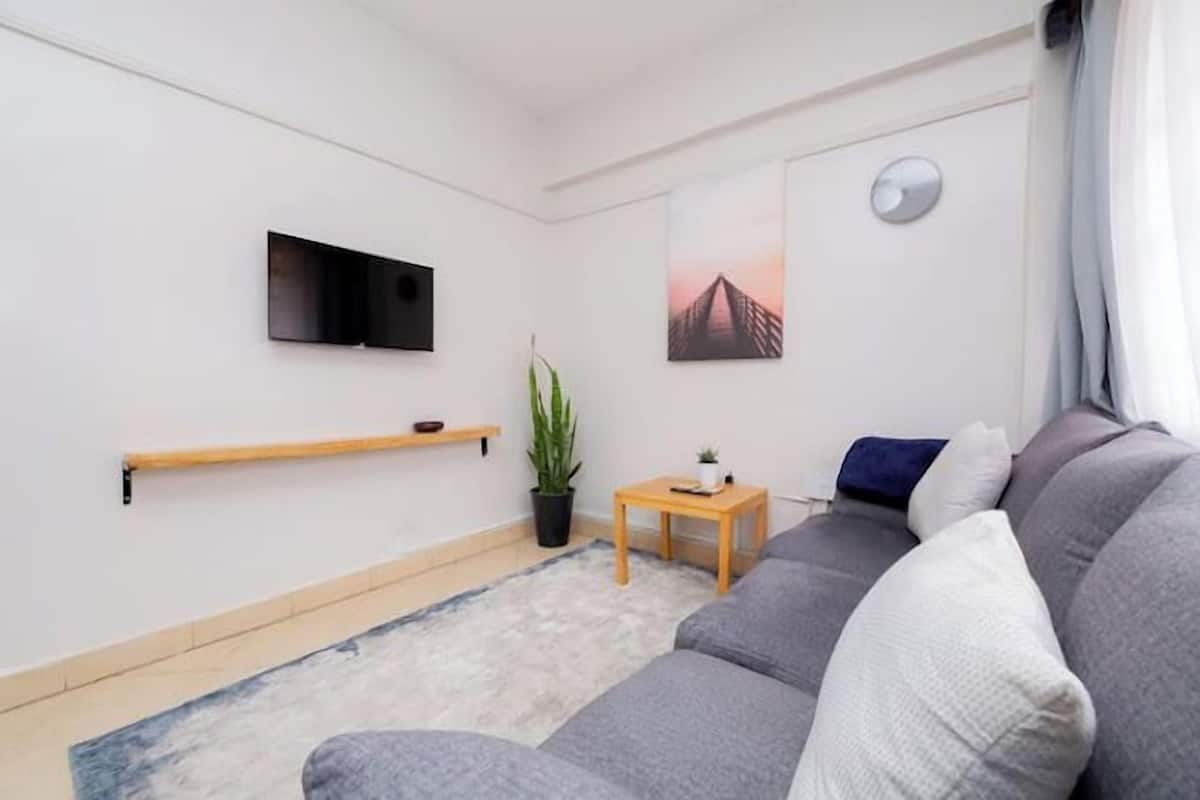 Apartamento clássico, vista para a cidade | Área de estar | Smart TV 34 polegadas com canais digitais