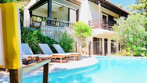 A pool area with lounge chairs and a stone wall. - Lili - Pool & View of Lake Carcès (Carcès)