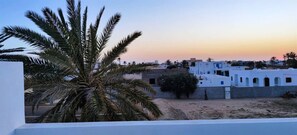 A coastal town with white buildings, palm trees, and a clear sky at sunset. - Villa Dar Ranya - 8 pers - Piscine privée - Midoun - Djerba -Plages à 2 km (Djerba Midun)