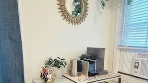 A kitchen area with a coffee station, a microwave, and a small refrigerator. - Ravenwood (Niagara-on-the-Lake)