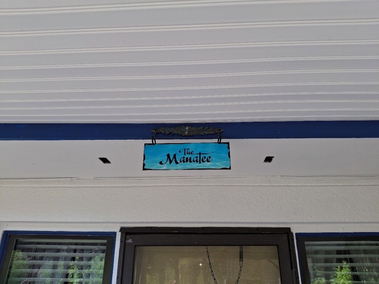 A building with a sign that reads "The Manatee" above a window.