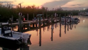 Un puerto deportivo tranquilo con barcos amarrados, pilotes de madera y cielo despejado.