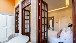 Una habitación de hotel con una cama, una mesa blanca y una silla.
