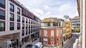 Um edifício com vários andares, fachada moderna, um pátio central e uma combinação de estilos arquitetônicos.