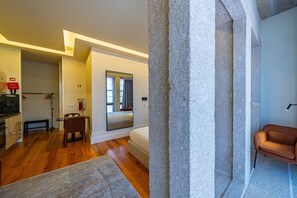 Interior moderno com piso de madeira, área de jantar, sofá e parede decorativa em pedra.