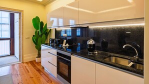 Eine moderne Küche mit schwarzer Arbeitsplatte, Edelstahlspüle und weißen Schränken.