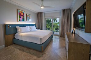 Quarto com cama, ventoinha no teto, televisão e varanda com cortinas.