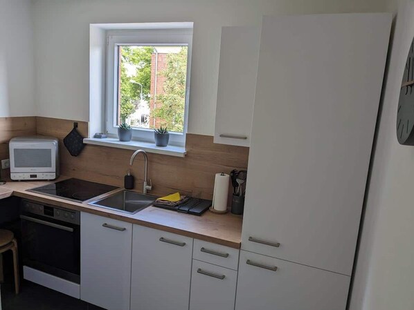Fridge, stovetop, dishwasher, coffee/tea maker