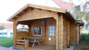 A wooden cabin with a picnic table and a door. - Ferienhaus Nemo Wohnung 6 "Dorie" (Rerik)