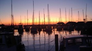 A marina at sunset with multiple sailboats docked. - Ferienhaus Nemo Wohnung 6 "Dorie" (Rerik)
