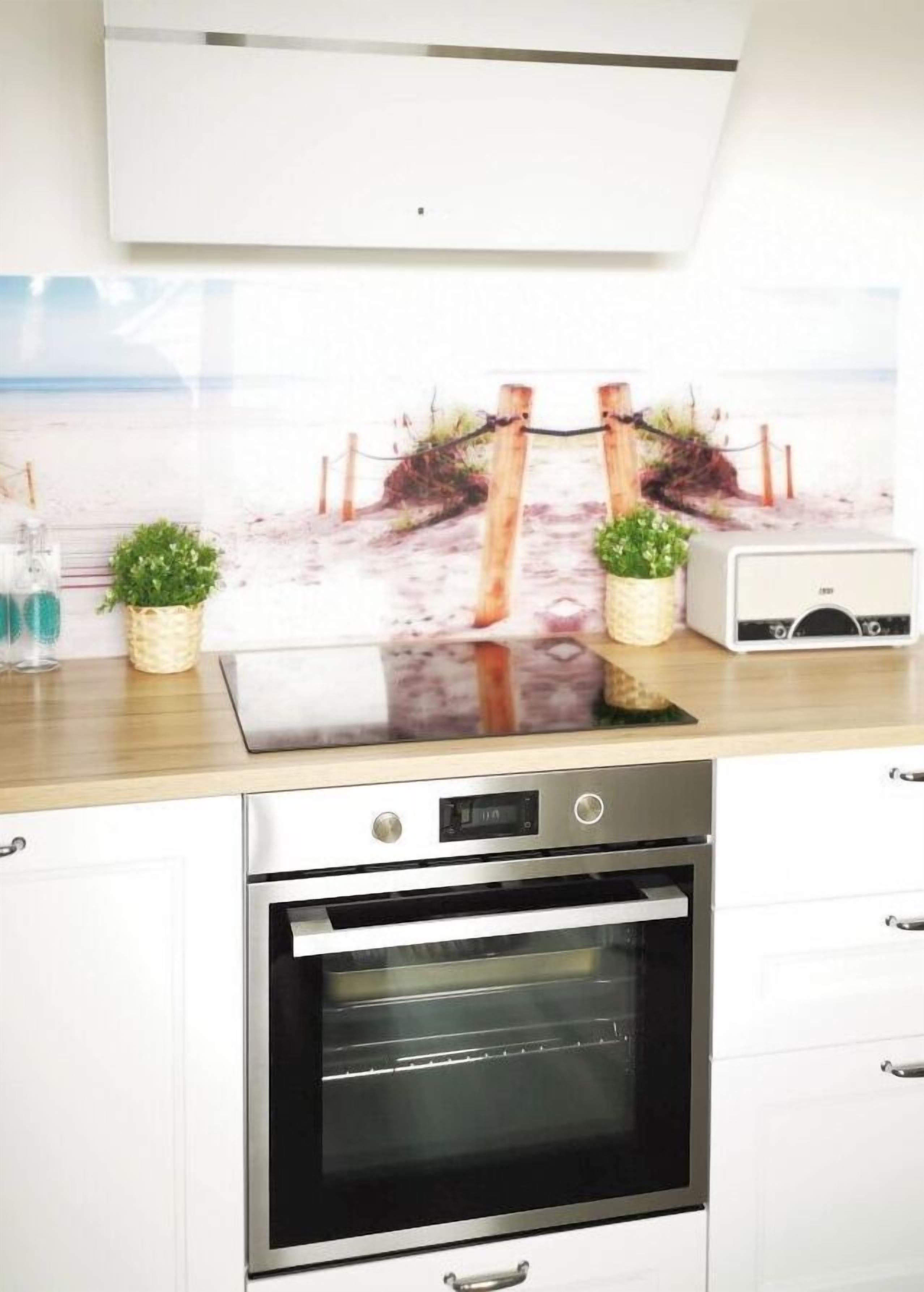 A kitchen with a built-in oven, a microwave, and a toaster. There are two potted plants on the counter.