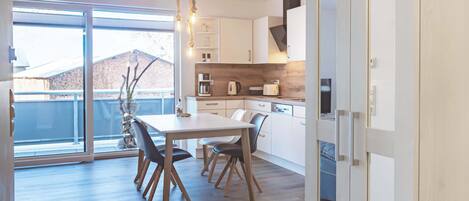 Una cocina moderna con comedor, ventanas amplias y vistas al exterior.
