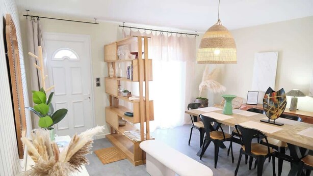 Zona pranzo con tavolo in legno, sedie, una panca e un lampadario.