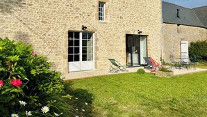 A stone building with a large window and a door, a small balcony, and outdoor seating. - Clos du Haut Gallion, An authentic haven of peace (Saint-Cyr)