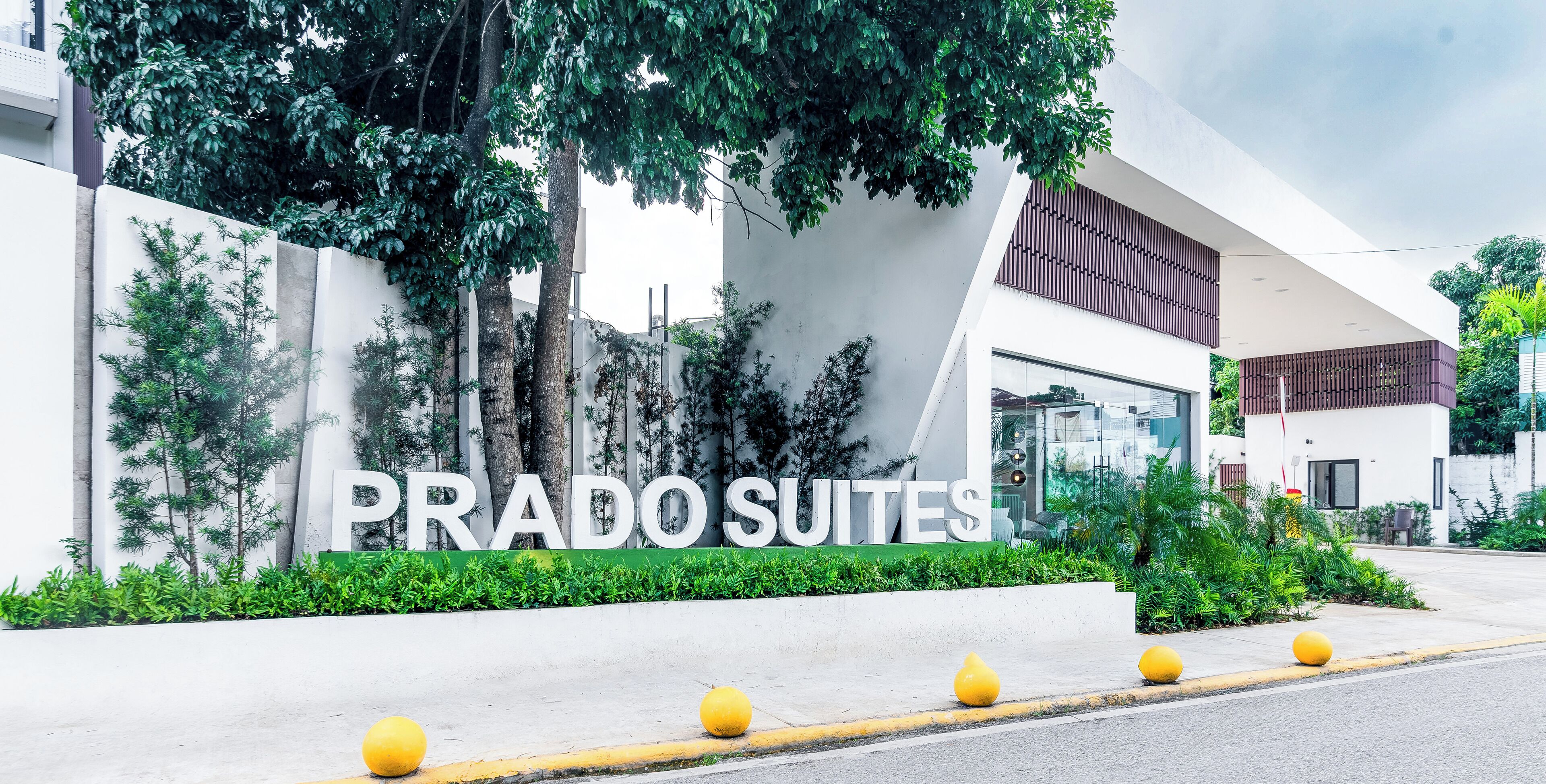 A modern building with a sign reading "PRADO SUITES".