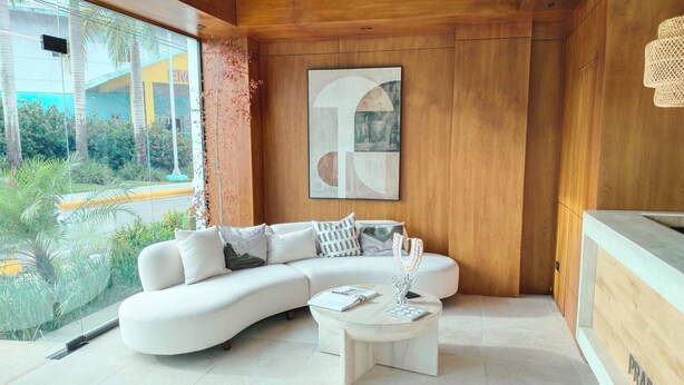 A modern living room with a white sectional sofa, a coffee table, and a large abstract painting on the wall. - Prado Suites Las Terrenas (Las Terrenas)