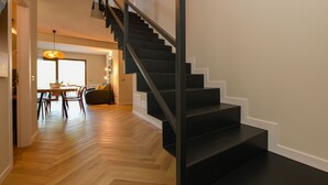 A modern interior with a staircase, wooden flooring, and a dining area. - Gardaliva 7 by the lake in Manerba (Manerba del Garda)