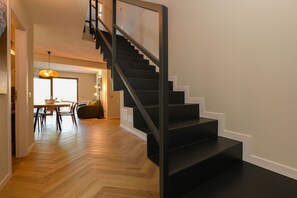 Ein modernes Interieur mit Treppe, Holzboden und Essbereich.